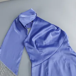 Detalle de vestido de satén morado con cuello halter y flecos plateados
