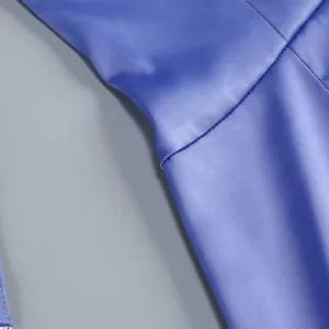 Primer plano del suave tejido de satén azul y las finas costuras de este elegante vestido