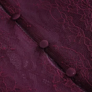 Detailed macro view of burgundy floral lace texture and elegant fabric-covered button closures