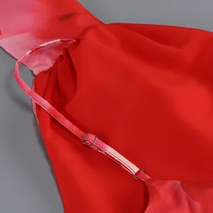 Detalle de primer plano de un vestido largo rojo con flores y tirante fino ajustable