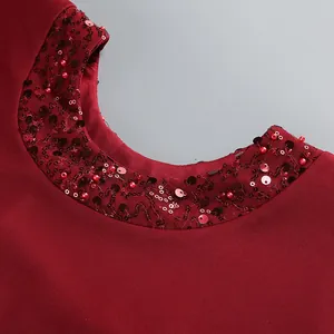 Vista macro detallada del escote de un vestido burdeos con elegantes lentejuelas y cuentas