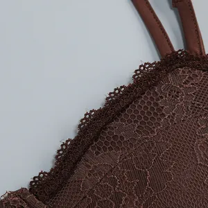 Close-up detail showing the intricate brown hollow-out lace and strap of the dress