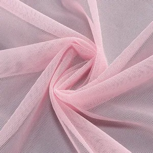 Primer plano de la delicada textura de tela de malla rosa con elegantes pliegues