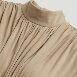 Primer plano de vestido sin mangas con cuello alto y detalles plisados finos