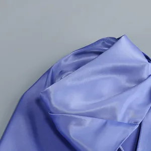 Primer plano de elegante tela de satén azul con brillo sedoso y costuras detalladas