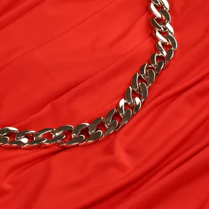Primer plano del detalle de la cadena dorada en el vestido de vacaciones rojo con escote en V