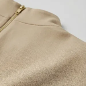 Primer plano de la textura de punto fino y cremallera en un vestido beige de cuello alto