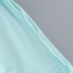 Primer plano de la tela plisada azul claro y detalles de costura de un vestido largo.