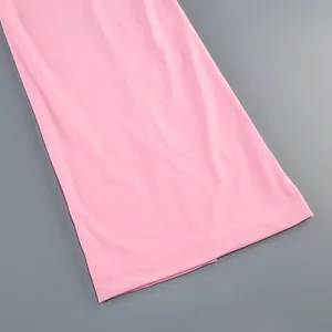 Detalle de cerca del dobladillo rosa liso de un vestido largo elegante de color sólido.