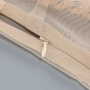 Primer plano de la cremallera oculta en un vestido largo de malla beige para vacaciones