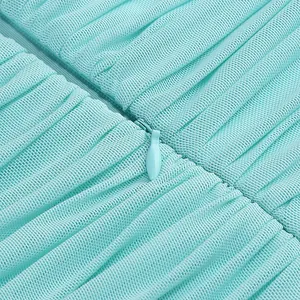 Detalle de un vestido plisado verde menta con una cremallera invisible a juego