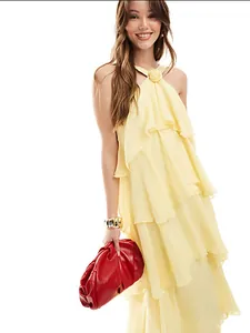 Elegante vestido amarillo de capas con volantes y detalle de flor en el cuello