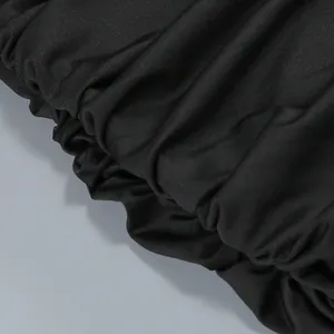 Detailed macro view of the black elasticized ruched fabric texture on a sexy evening gown