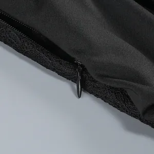 Close-up detail of invisible zipper and lace trim on black evening dress.