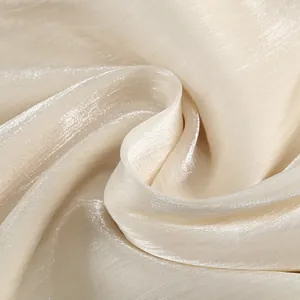 Detailed macro view of shimmering cream silk-like fabric for French luxury dinner dress