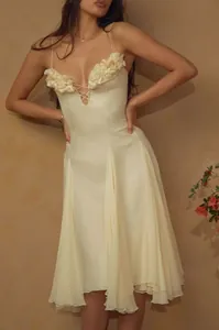 Detalle de vestido midi crema de estilo francés con apliques florales y cordones