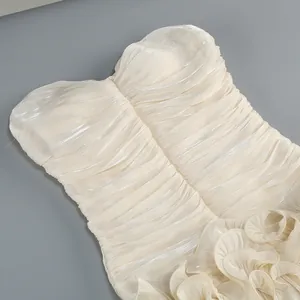 Exquisite macro detail of shimmering pleated fabric on an elegant cream strapless dress