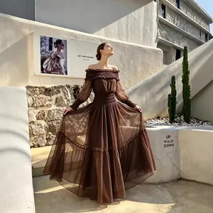 Elegante vestido largo marrón de malla con hombros descubiertos, cintura smock y mangas.