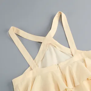 Vista detallada del diseño de espalda cruzada y los volantes en un vestido de color crema