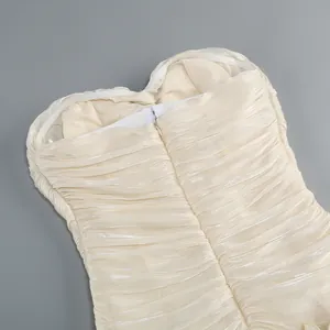 Detailed view showing the ruched fabric texture and back zipper of a champagne dress
