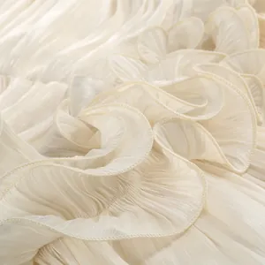 Macro detail of elegant cream pleated ruffles on a French style luxury evening dress