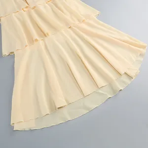Primer plano de los elegantes volantes en capas de un vestido de gasa color albaricoque