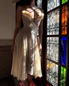 Detalle de vestido blanco de estilo francés con flores y sombras artísticas