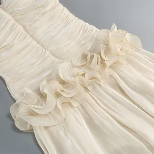 Close-up detail of luxurious ruffled layers on an elegant champagne pleated evening gown