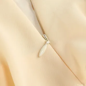 Primer plano detallado de una cremallera invisible en un vestido de moda albaricoque