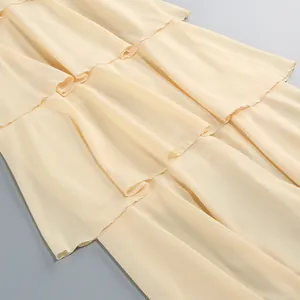 Primer plano detallado de los volantes de gasa en capas de un elegante vestido amarillo crema
