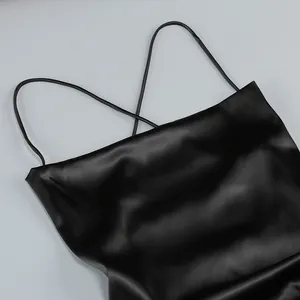 Primer plano detallado del escote de un vestido de satén negro con finos tirantes cruzados