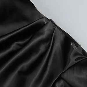 Primer plano de la tela de satén negro con un drapeado elegante y textura suave