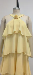 Detalle de elegante vestido de gasa amarillo con decoración de rosa tridimensional