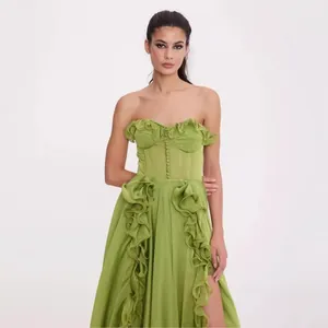 Elegante vestido palabra de honor verde lima con corpiño volantes, botones y abertura alta.