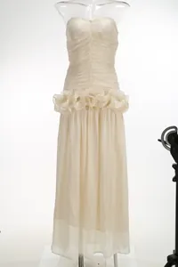 Detailed view of champagne strapless evening dress with pleated bodice and ruffled waist