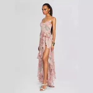 Detailed side view of a pink floral ruffled maxi dress featuring a high thigh slit and cowl neck