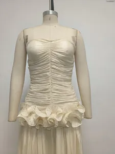 Detail of the intricate ruching and ruffled waist on this cream strapless evening gown.