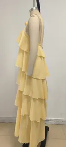 Vista lateral de un elegante vestido amarillo con volantes en capas y diseño sin espalda.