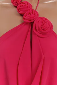 Primer plano de rosas de tela 3D fucsia en un elegante vestido de fiesta de cuello halter