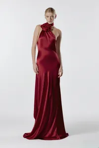 Elegante vestido de noche de satén rojo con gran detalle de rosa y cuello tipo halter.