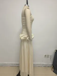 Side view of a cream strapless evening gown with elegant ruffled waist detail for party.