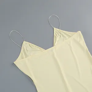 Detalle de cerca de los finos tirantes de cadena plateada en un vestido amarillo de estilo francés