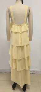 Vista trasera de vestido amarillo de capas con espalda abierta y volantes en maniquí