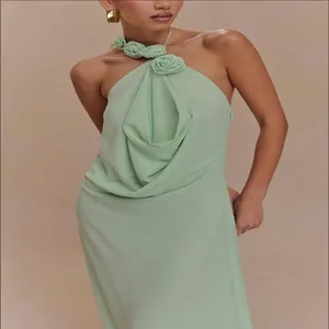 Primer plano de un elegante vestido halter verde claro con exclusivos detalles florales 3D al cuello