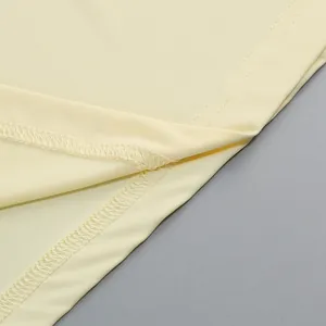 Detalle de tela amarilla lisa y costuras precisas en un vestido de verano de estilo francés