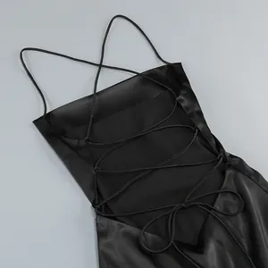 Detalle del vestido de satén negro con espalda descubierta y tirantes cruzados