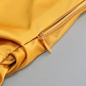 Vista macro detallada que muestra la cremallera invisible y la textura del raso amarillo.
