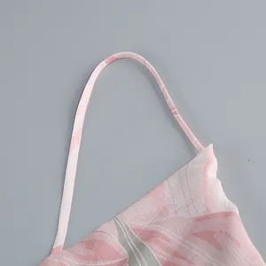 Close-up of pink floral print dress featuring a thin spaghetti shoulder strap detail.