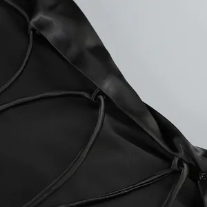 Primer plano del detalle de cordones y tela de satén de un vestido negro sin espalda