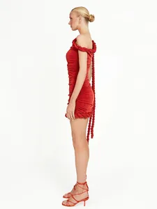 Vista lateral del vestido rojo ajustado con ribete de cuerda trenzada y detalles plissés